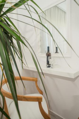a bathroom with a wooden chair and a mirror at Elizabeth Suites in Kato Daratso