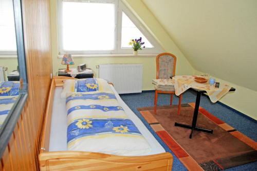 バーベにあるPension mit Fruehstueck im Ostseebadのベッド2台、テーブル、窓が備わる客室です。