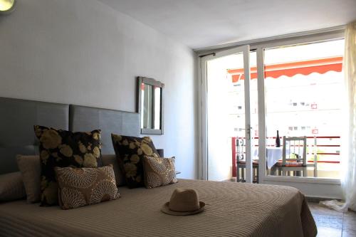 プラヤ・デ・ラス・アメリカスにあるOlympia vista mare by Holiday Worldのベッドルーム(ベッド、帽子付)