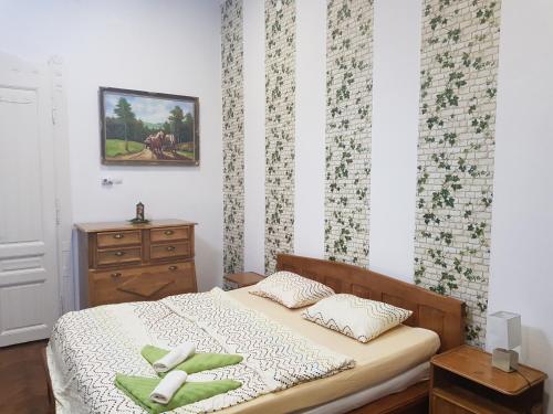 オラデアにあるApartament in vila Secessionのベッドルーム1室(緑の枕とドレッサー付きのベッド1台付)