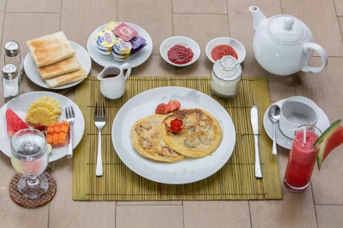 een tafel met borden eten op een tafel bij Gajah Villas Bali by Nagisa Bali in Seminyak