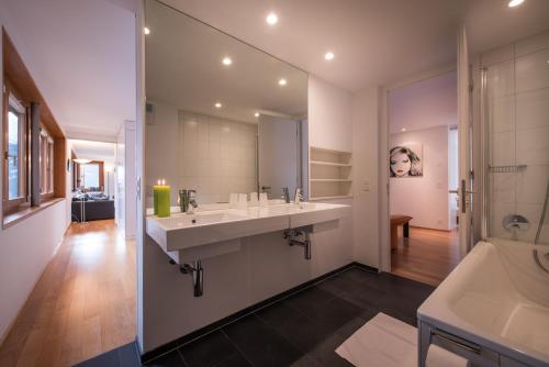 a bathroom with two sinks and a large mirror at Chalet Dillon in Wengen