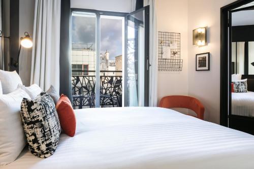 1 dormitorio con 1 cama blanca grande y ventana en Laz' Hotel Spa Urbain Paris, en París