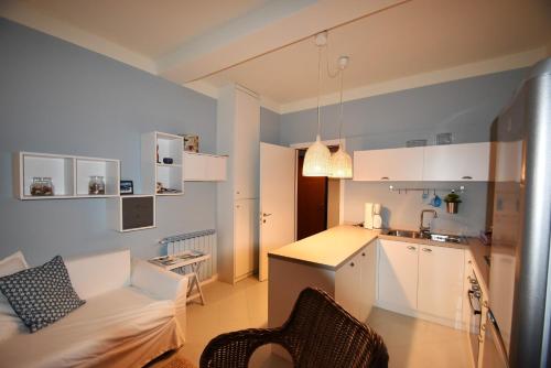 uma sala de estar com um sofá e uma cozinha em Casa Marina by Holiday World em Ghiffa