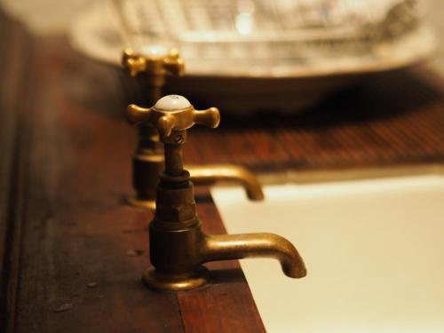 a brass water faucet on a wooden table at No.33 Coach House in Hillsborough