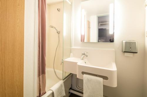 a white bathroom with a sink and a shower at B&B HOTEL Grenoble Université in Gières