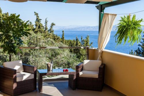 balcón con sillas, mesa y vistas al océano en Villas Muscalas by Konnect, 200m from the Beach en Lákka