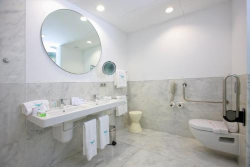 a bathroom with a sink and a mirror and a toilet at Hotel Hiberus in Zaragoza