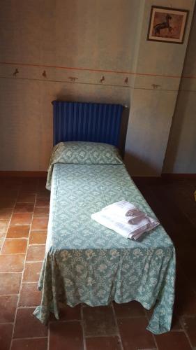 a bed with a blue headboard in a room at Agriturismo La.Ti.Mi.Da. in Cassine