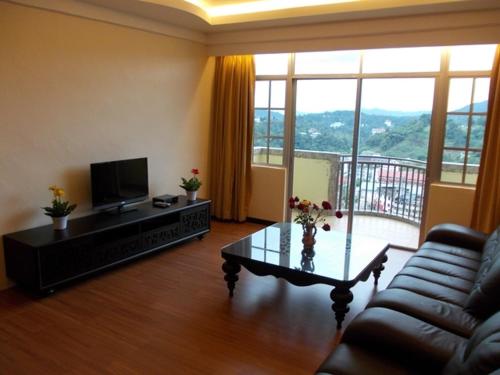uma sala de estar com um sofá e uma mesa de centro em Bali Style Apartment @ Imperial Court em Cameron Highlands