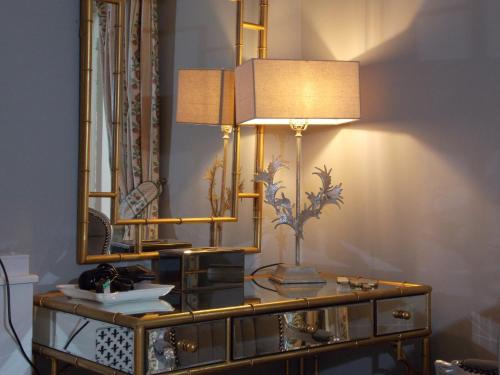 a dressing table with a mirror and a lamp on it at Rectory Manor in Lavenham
