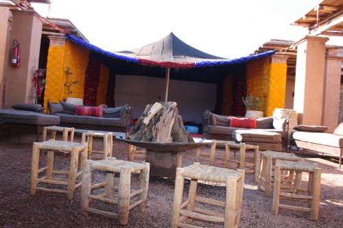 a group of wooden stools and a table and chairs at Terres d'Amanar in Tahannout