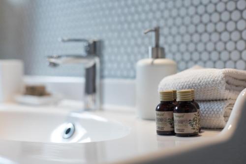 two bottles of medicine sitting on a bathroom sink at Mami's Home Trastevere apt with private terrace in Rome