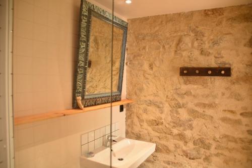 uma casa de banho com um lavatório e uma cabina de duche em vidro. em Les Maillettes em Les Épesses