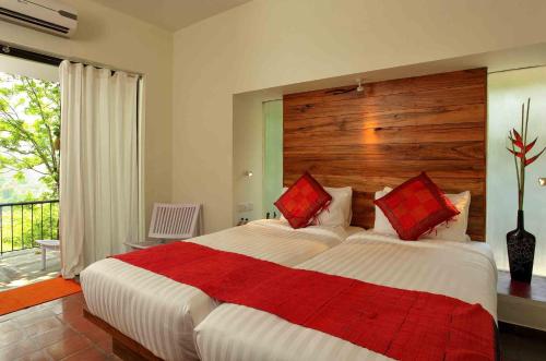 a bedroom with a large bed with a wooden headboard at Rainforest Resort in Athirappilly