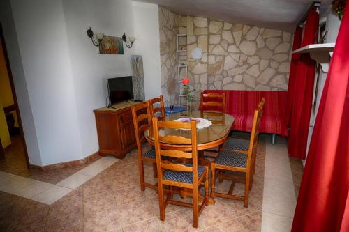 a dining room with a table and chairs and a television at Apartments Coki in Funtana