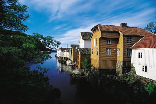 a row of houses next to a river at Sogndalstrand Kulturhotell in Sogndalsstrand