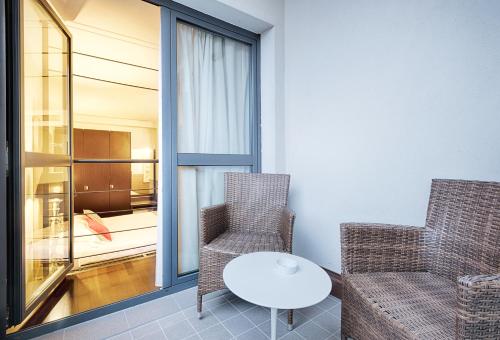 ゾーラ・プレドーザにあるContinental Urban Art Hotelの窓のある客室で、椅子2脚とテーブル1台が備わります。