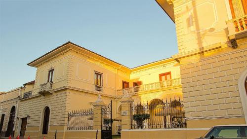 a large yellow building with a fence in front of it at Hotel la Perla Leon in León