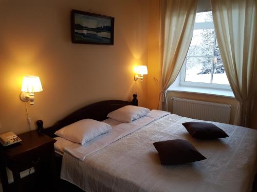 a bedroom with a bed with two pillows on it at Birinu Pils in Bīriņi