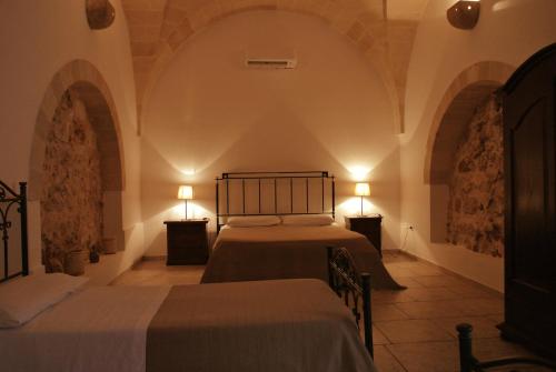 a bedroom with two beds and two lamps at Masseria Nuova in Francavilla Fontana