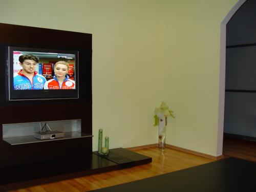 ein Wohnzimmer mit einem TV an der Wand in der Unterkunft Apartment on Prospekt Masherova 26 in Brest