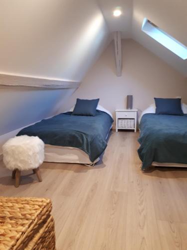 オンフルールにあるAppartement cosy dans le centre de Honfleurのベッドルーム(ベッド2台付)が備わる屋根裏部屋です。