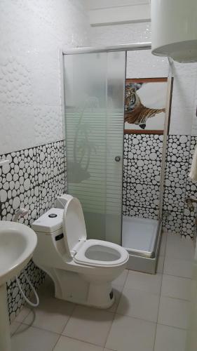
a white toilet sitting next to a bath tub in a bathroom at Winta Hotel in Hārer
