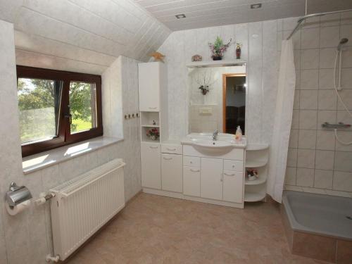 a bathroom with a sink and a toilet and a window at Ferienwohnung mit Terrasse in Kropelin in Klein Nienhagen