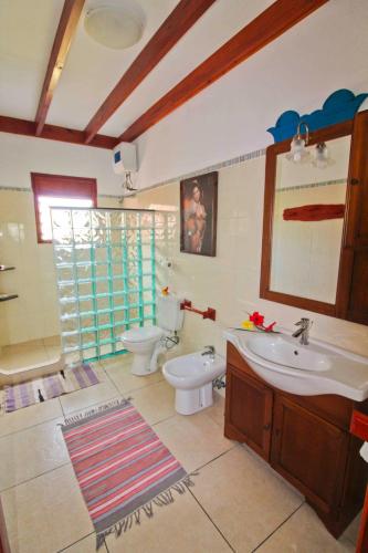 a bathroom with a sink and a toilet at Takamaka Green Village in Takamaka