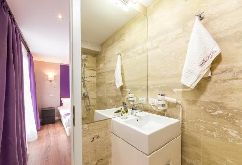 a bathroom with a sink and a mirror at The Embassy Nord in Bucharest