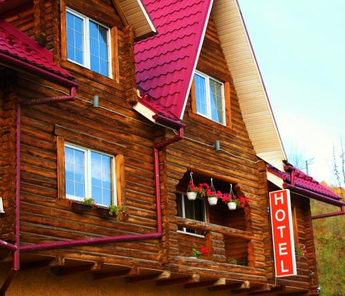 a log cabin with potted plants on the windows at "LiAn" Family Hotel & Restaurant in Volosyanka