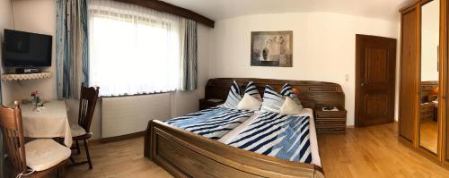 a bedroom with a bed with blue and white striped pillows at Gästehaus Margareta in Wald im Pinzgau