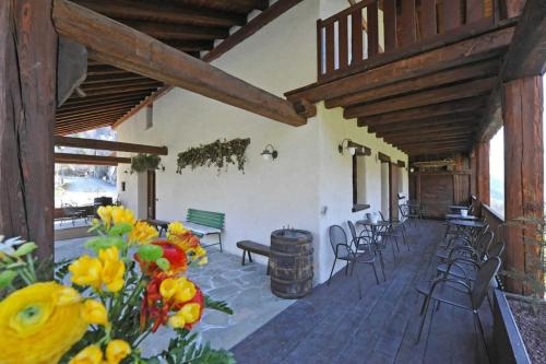 a patio with a bunch of chairs and flowers at Maison Tissiere in Antey-Saint-André