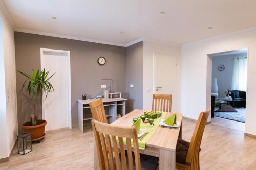 a dining room and living room with a table and chairs at Ferienwohnung Ulrike in Blieskastel