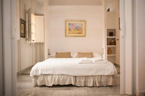a white bedroom with a large white bed in it at CATEDRAL, GRAN PATIO, PLENO CENTRO in Seville