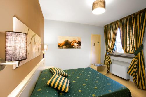 a bedroom with a green bed and a window at Hotel La Campagnola in Fucecchio