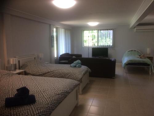 1 dormitorio con 2 camas y sala de estar con sofá en Stretton Lane en Townsville