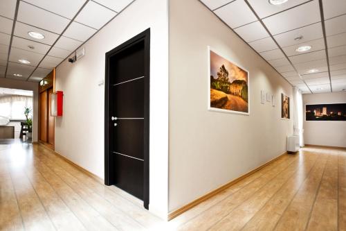 an empty hallway with a door and paintings on the wall at Hotel La Campagnola in Fucecchio