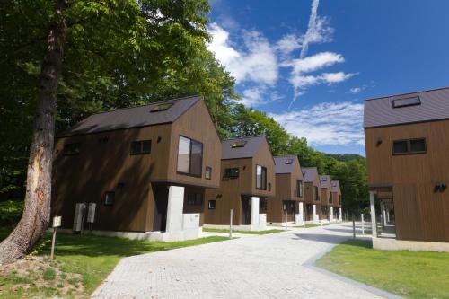 a row of houses on a street with trees at Gakuto Villas in Hakuba