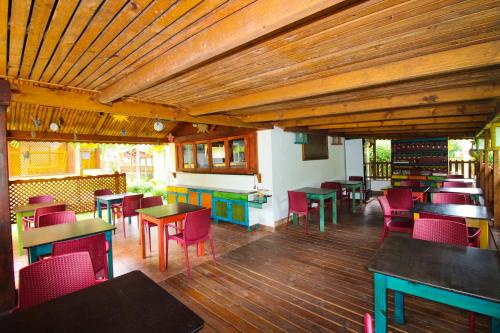 タカマカにあるTakamaka Green Villageの多くのテーブルと椅子、木製の天井が備わるレストランを併設しています。