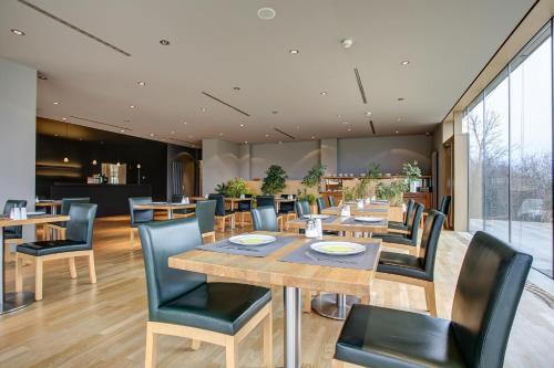 a dining room with wooden tables and chairs at Centro Park Hotel Stuttgart, Trademark Collection by Wyndham in Ostfildern
