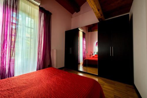 a bedroom with a red bed and a large window at Tenuta La Fiscala in Alessandria
