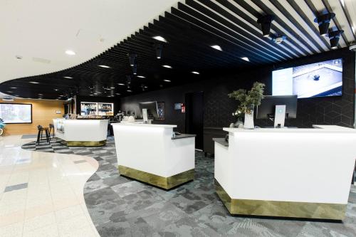 a lobby with white counters and a tv at Hotel Sveitsi in Hyvinkää