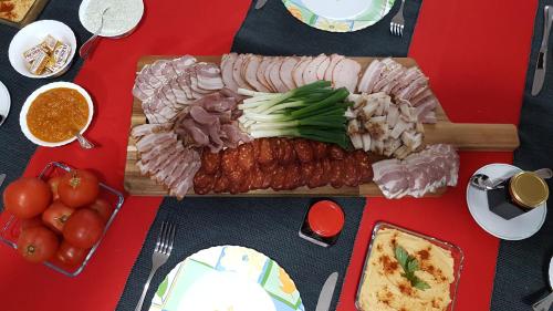 un tagliere con carne e ortaggi su una tavola di Pensiunea Casa Runcu Buzau a Runcu