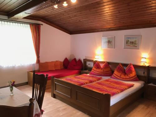 1 dormitorio con cama, sofá y mesa en Gästehaus Margareta en Wald im Pinzgau