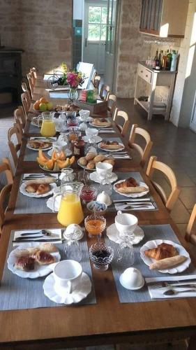 une longue table avec des assiettes de nourriture dans l'établissement Le Pré Vert, à Crugey