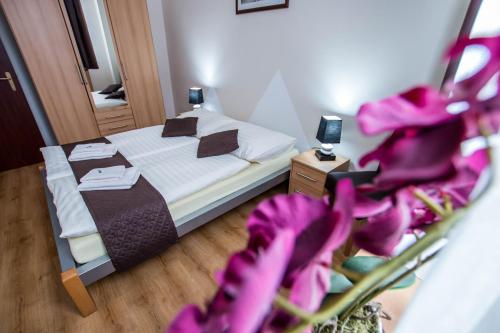 ein Schlafzimmer mit einem Bett mit lila Blumen in der Unterkunft Penzion FIT - Contactless check in in Zvolen