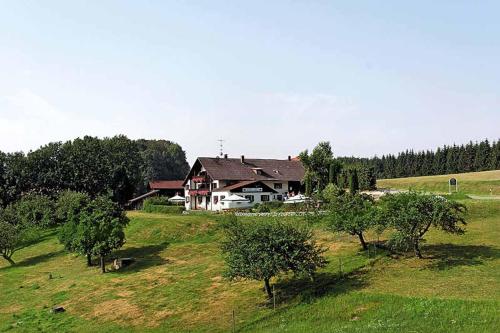 una casa en una colina en un campo con árboles en Landhaus Lehnerhof, en Schaufling