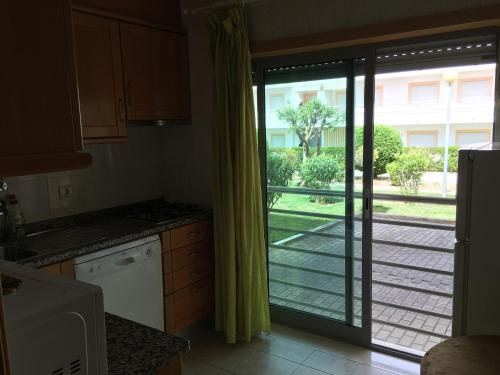 a kitchen with a sliding glass door to a yard at Lovely Studio Marta on the beach Falesia, Albufeira in Albufeira